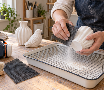 Maker sanding a white plaster casting with black drywall sanding screen over a dust collection tray
