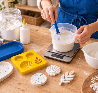 Home crafter weighing and mixing wood glue with Plaster of Paris beside silicone moulds