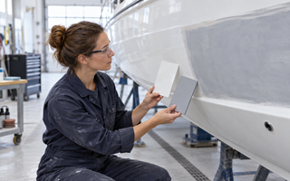 Woman comparing a polished gelcoat panel with a rolled marine paint finish on a boat