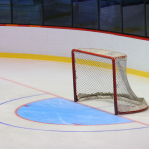 empty hockey arena with view of net from diagonal angle