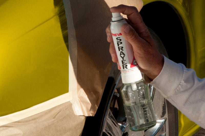 Manufacturer demonstration of a Preval sprayer used beside a masked automotive panel