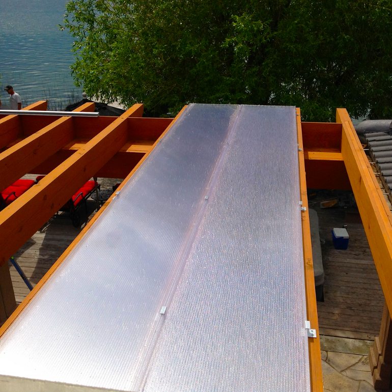 Close view of clear three-wall polycarbonate roof panels and raised standing seams