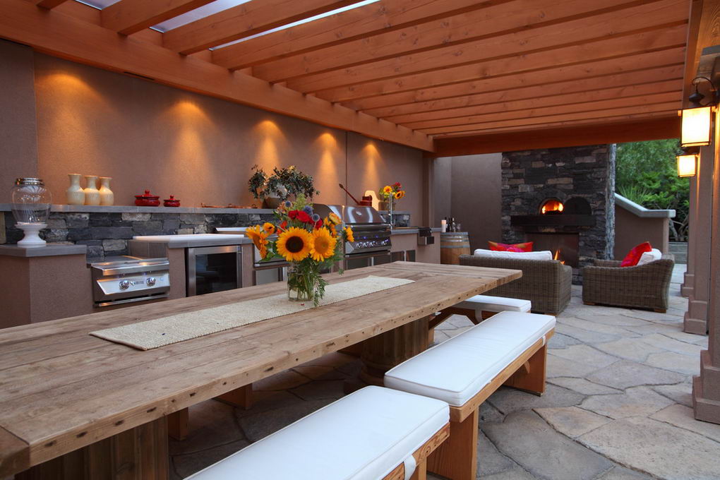 Outdoor kitchen combining timber stone stainless steel and clear polycarbonate roofing